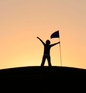 Person with a flag symbolizing reaching personal goals